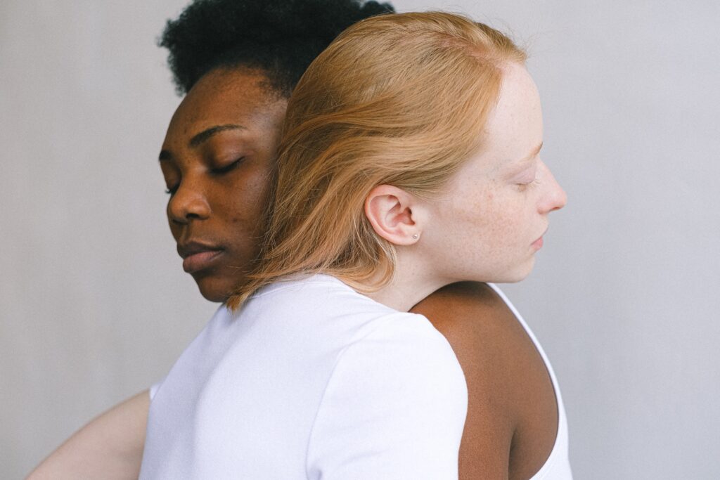 2 women one black one white hugging
